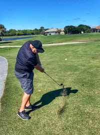 a man hitting a golf ball on a golf course