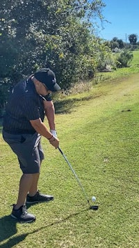 a man hitting a golf ball on a golf course